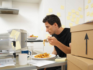 عکس مرد در حال کار کردن و غذا خوردن