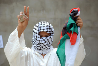 عکس فلسطینی با پرچم و سنگ