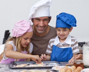 عکس پدر و فرزندان در حال شیرینی پزی
