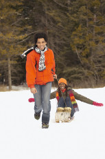 عکس زن و مرد در حال سورتمه سواری در برف