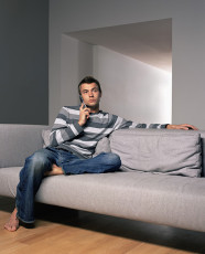 عکس مرد با موبایل روی کاناپه