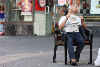 عکس پیرمرد روی نیمکت در خیابان