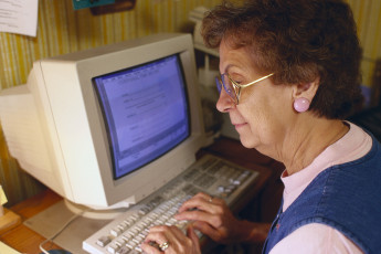 عکس پیرزن در حال کار با کامپیوتر